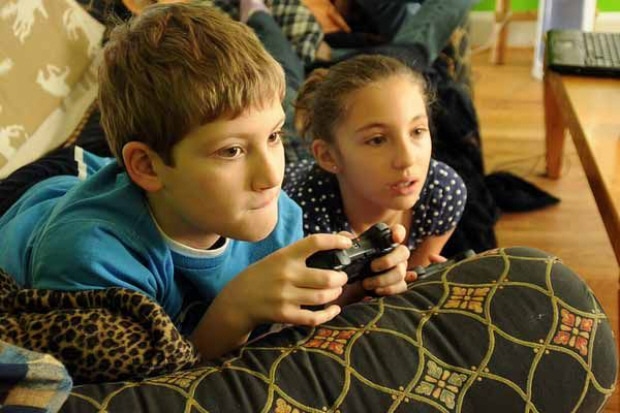 Kids playing videogames (boy & girl). The proper way to raise a child